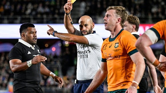 Referee Andrea Piardi shows a yellow card to Australia’s Harry Potter
