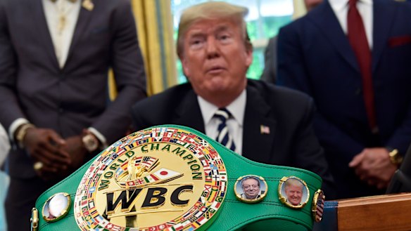 A boxing belt presented to Donald Trump sits on the desk in Oval Office as he pardons Jack Johnson.