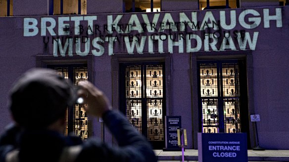 The words "Brett Kavanaugh Must Withdraw" are projected by demonstrators onto the E. Barrett Prettyman United States Courthouse in Washington, DC. 