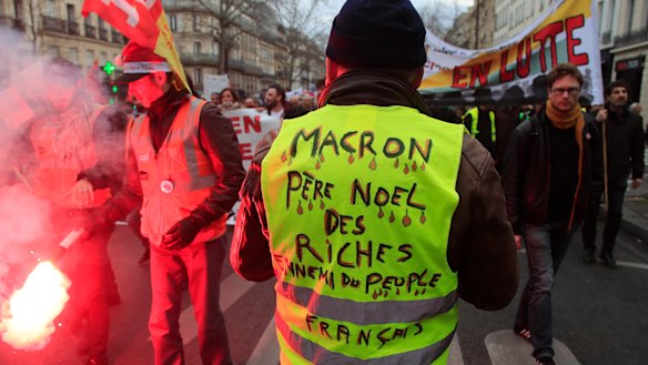A Yellow Vest protester attends a demonstration in Paris on Thursday. His vest says "Macron, Father Christmas to the rich, enemy of the French people".