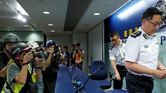 Press photographers wearing helmets for protection in the clashes seen in recent protests, photograph a press conference by Commissioner of Police Stephen Lo in Hong Kong.