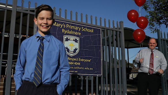 Smiles and balloons: Sandy Keyser is greeted by his principal Richard Blissenden at the school gates on Friday.