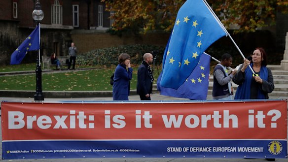 An anti-Brexit supporter holds a European flag by a banner across the street from the Houses of Parliament in London.
