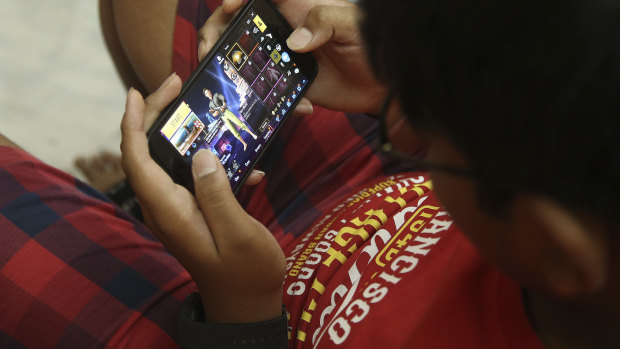 An Indian boy plays an online game PUBG on his mobile phone in Hyderabad.