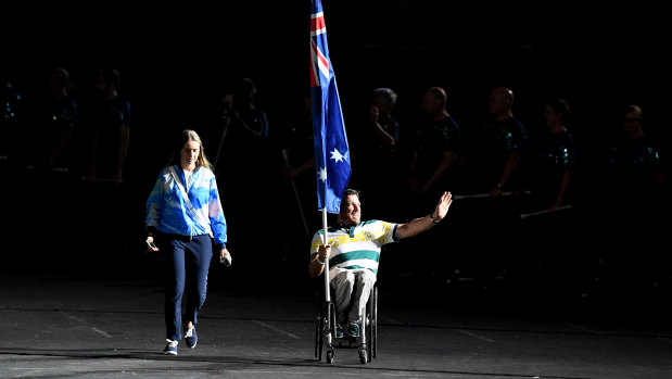 Kurt Fearnley carries the Australian flag into the closing ceremony on Sunday night.