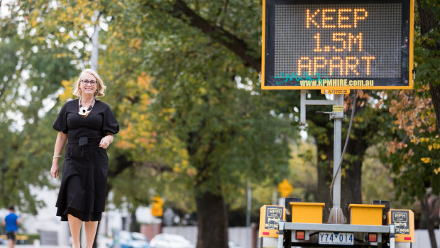 Melbourne lord mayor Sally Capp next to a sign urging social distancing.