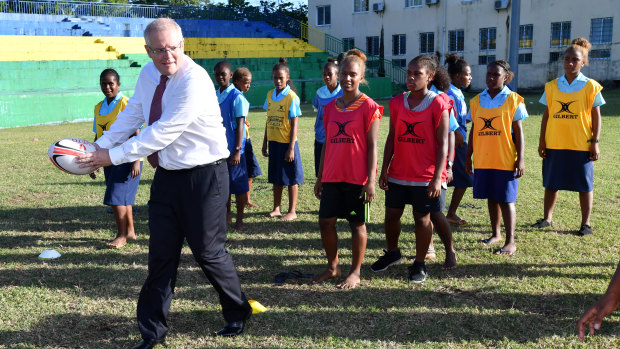 Prime Minister Scott Morrison plays rugby with students in Honiara, Solomon Islands, on Monday.