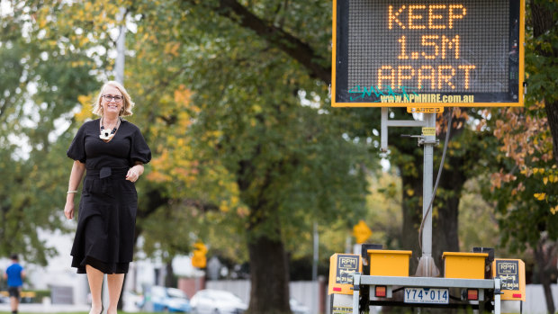 Melbourne lord mayor Sally Capp yesterday next to a sign urging social distancing.