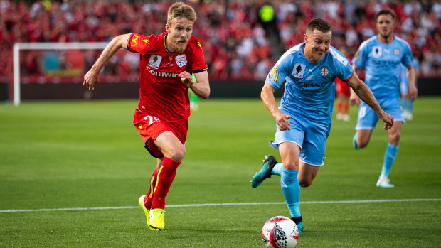 Race for the prize: Adelaide's Ben Halloran bursts forward under pressure from City's Scott Jamieson.