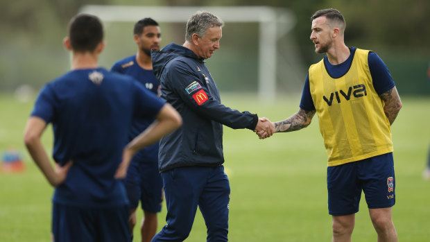 Keeping busy: The suspended Roy O'Donovan shakes hands with Newcastle Jets coach Ernie Merrick at training.