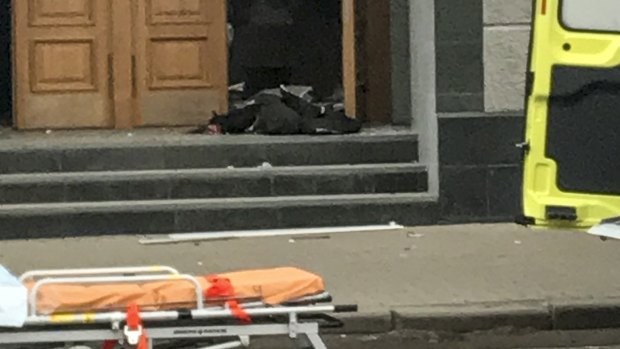 A teenager who set off a bomb at the FSB office in the city of Akhangelsk lies on the ground at the entrance.