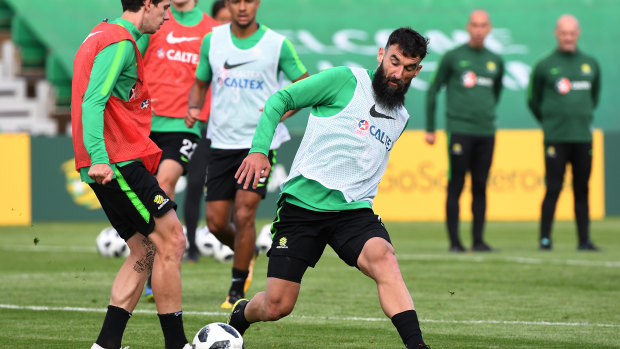 Benched: Mile Jedinak tackles Robbie Kruse in a training session in Kazan.