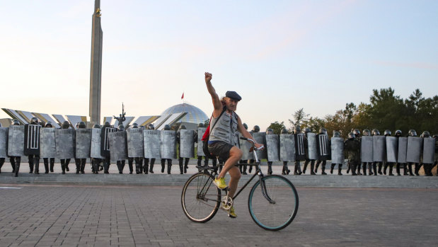 A protester rides a bicycle in front of police during an opposition rally to protest against the presidential inauguration in Minsk, Belarus.