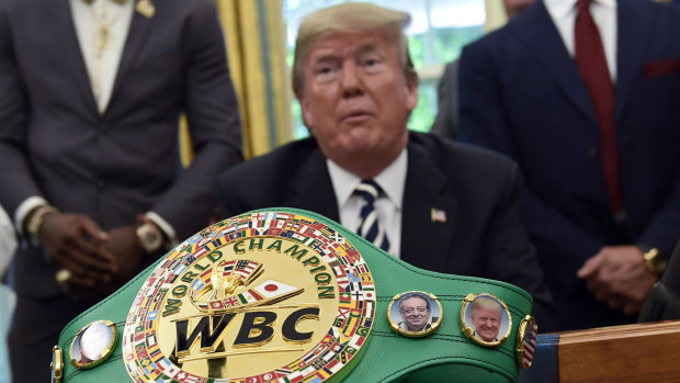 A boxing belt presented to Donald Trump sits on the desk in Oval Office as he pardons Jack Johnson.