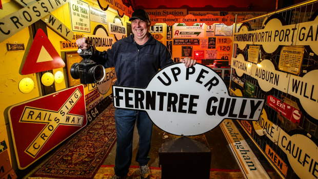 Graham Dann, pictured at Yarra Valley Auctions, with the station sign he drove for three hours to buy and a vintage railway lantern.