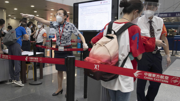 Airline employees directing travellers at the check-in in Beijing: The country's aviation regulator recommends stepping up COVID-19 safety regulations further on board.