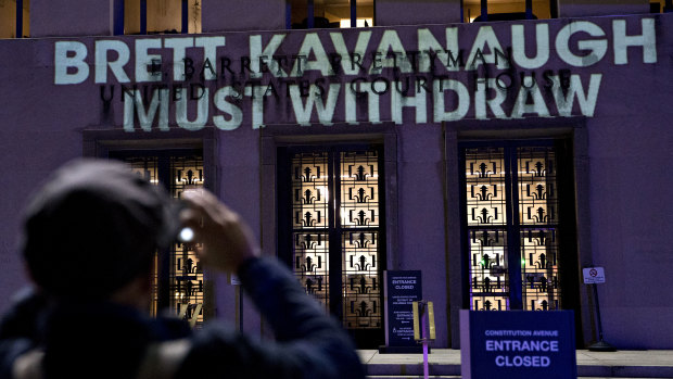 The words "Brett Kavanaugh Must Withdraw" are projected by demonstrators onto the E. Barrett Prettyman United States Courthouse in Washington, DC. 