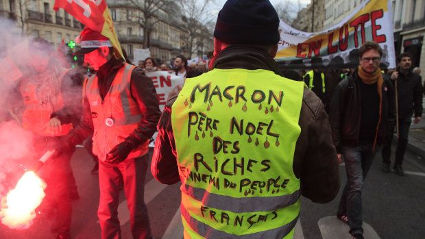 A Yellow Vest protester attends a demonstration in Paris on Thursday. His vest says "Macron, Father Christmas to the rich, enemy of the French people".