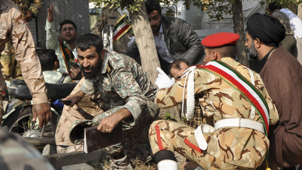  Iranian armed forces members and civilians take shelter from the  shooting.