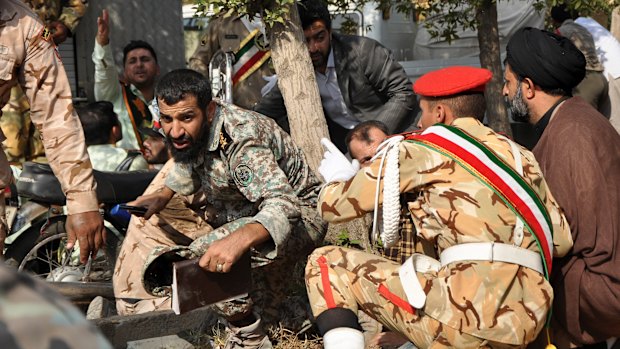  Iranian armed forces members and civilians take shelter from the  shooting.