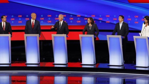 Tulsi Gabbard (in white) and Democratic candidates assembled for a presidential primary debate in 2019.