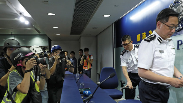 Press photographers wearing helmets for protection in the clashes seen in recent protests, photograph a press conference by Commissioner of Police Stephen Lo in Hong Kong.