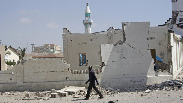 A man walks past destroyed buildings after a large blast in  Mogadishu, Somalia, on December 22.