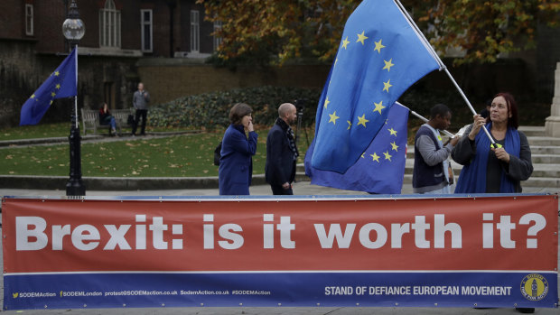 An anti-Brexit supporter holds a European flag by a banner across the street from the Houses of Parliament in London.