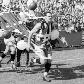 Ray Gabelich leads the Collingwood team on to ground.