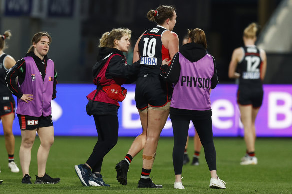 Erin McKinnon is helped from the field.