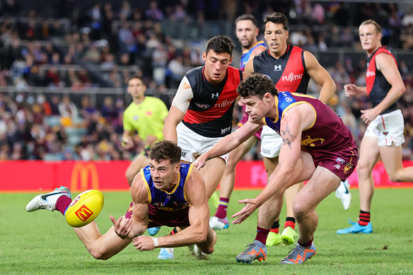 Josh Dunkley shovels out a handpass against Essendon, showing the hard-nosed approach that has immediately endeared him to Brisbane Lions teammates and supporters.
