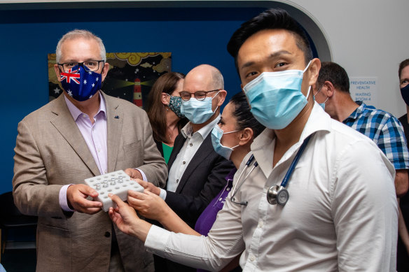 Dr Li, right, holding the vaccine vials. 