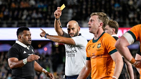 Referee Andrea Piardi shows a yellow card to Australia’s Harry Potter