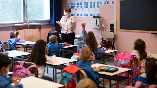 Children wear protective masks inside a school.