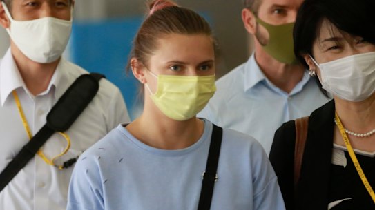 Belarusian Olympic sprinter Krystsina Tsimanouskaya, centre, at the airport in Tokyo before her flight to Austria.
