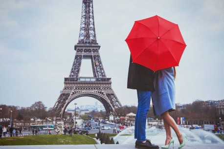 A couple embrace at the Eiffel Tower, Paris. It’s such a cliche. 