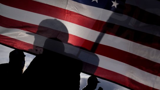 Supporters of President-elect Joe Biden and Vice President-elect Kamala Harris wave flags in Las Vegas a week ago.