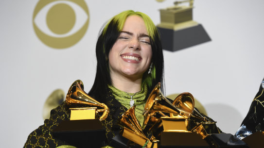 Billie Eilish poses with her Grammy Awards after the ceremony.