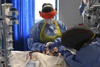 Hospital staff care for a patient with coronavirus in the intensive care unit at the Royal Papworth Hospital in Cambridge, England.