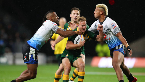 Daly Cherry-Evans of Australia is tackled by Siti Moceidreke and Viliame Kikau.