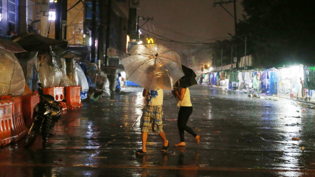 Commuters brave the rain and strong winds brought about by Typhoon Mangkhut.