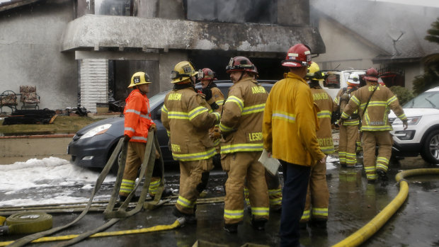 Firefighters outside one of the wrecked homes in Yorba Linda, California.
