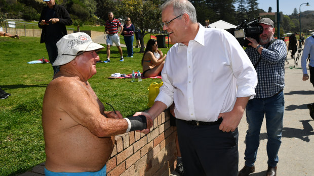 Prime Minister Scott Morrison shakes the hand of a local during a visit to Bronte Beach  on Friday.