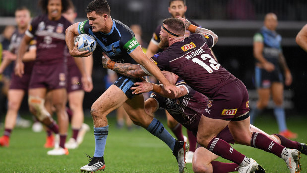 NSW halfback Nathan Cleary is brought down by Queensland's Tim Glasby (left) and Josh Mcguire.
