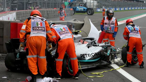 Officials attend to Valtteri Bottas' car after the Mercedes driver hit the wall.
