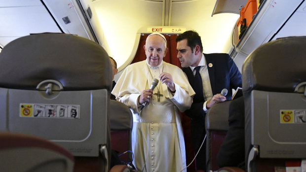 Pope Francis, flanked by interim director of Holy See Press Office, Alessandro Gisotti, speaks to reporters on board a plane to Rome.