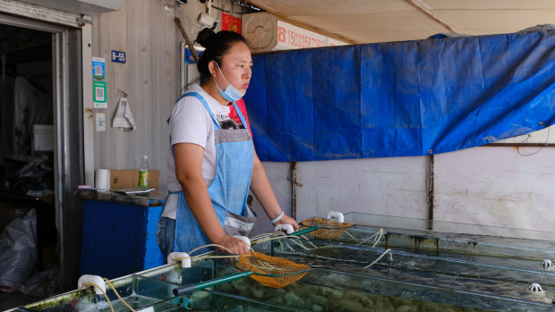 Zhang Meng waits for customers at her seafood shop in Beidaihe. 