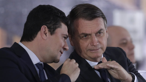 Brazil's President Jair Bolsonaro, right, talks with his Justice Minister Sergio Moro, the former judge who championed corruption investigations and jailed Lula.