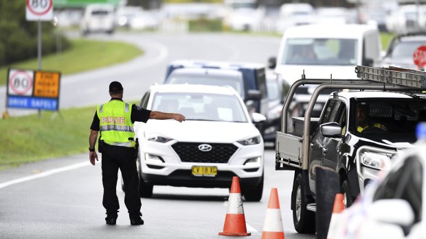 Vehicles arriving from NSW queue at a police checkpoint at the Queensland-NSW border in Coolangatta on Monday.