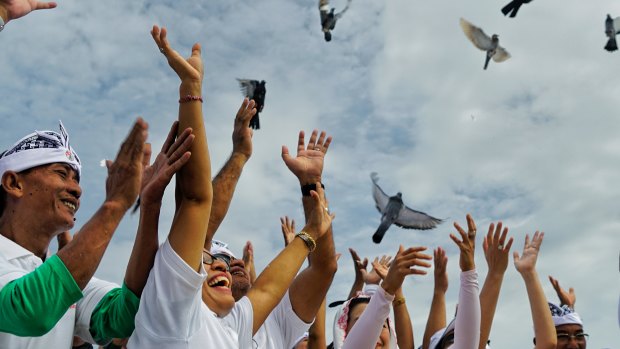 Doves are released during a ceremony at a beach at Nusa Dua.
